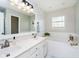 Bright bathroom features dual sinks, soaking tub with white tile, a window, and modern fixtures at 15638 River Birch Rd, Westfield, IN 46074