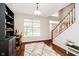 Open foyer with hardwood floors, staircase, and built-in black shelving unit at 15638 River Birch Rd, Westfield, IN 46074