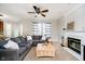 Cozy living room with fireplace, ceiling fan, neutral carpet, and large sectional sofa at 15638 River Birch Rd, Westfield, IN 46074