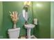 Charming powder room with green walls, pedestal sink, and decorative accents at 17301 Dallington St, Westfield, IN 46074