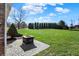 Spacious backyard featuring a patio with fire pit and a row of evergreen trees at 195 Hess Rd, Martinsville, IN 46151