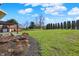 Expansive backyard with lush lawn, mature trees, landscaping, and a paved patio with pergola at 195 Hess Rd, Martinsville, IN 46151