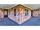 Inviting covered front porch with brick accents and a black entry door at 195 Hess Rd, Martinsville, IN 46151
