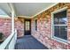 Welcoming front porch featuring brick walls, black flooring, and a stylish black door at 195 Hess Rd, Martinsville, IN 46151