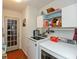 Functional laundry room featuring modern washer and dryer units, ample storage shelves, and a convenient exterior door at 198 Rapid Rill Ln, Brownsburg, IN 46112