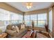 Bright sunroom filled with natural light from many windows; features neutral decor, comfortable seating, and a cozy rug at 198 Rapid Rill Ln, Brownsburg, IN 46112