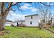 Expansive backyard with mature trees, multiple decks, green grass, and a gentle slope toward the waterway at 207 E Ohio St, Mooresville, IN 46158