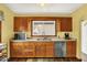 Functional kitchen featuring wood cabinets, stainless steel appliances, a large window, and modern flooring at 207 E Ohio St, Mooresville, IN 46158