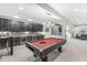 Basement rec room featuring a pool table, bar area, custom cabinets, and seamless connection to a comfortable seating area at 209 North Bnd, Greenwood, IN 46142