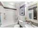 Clean bathroom featuring a tub, granite countertop, decorative mirror, and ample storage at 209 North Bnd, Greenwood, IN 46142