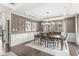 Elegant dining room featuring a modern chandelier, dark hardwood flooring, and views of the landscaped yard at 209 North Bnd, Greenwood, IN 46142