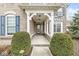 Inviting front porch with white pillars, a glass front door, trimmed shrubs, and meticulous landscaping at 209 North Bnd, Greenwood, IN 46142
