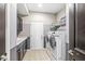 Modern laundry room with front load machines, sink, tile flooring, and stylish dark cabinets at 209 North Bnd, Greenwood, IN 46142