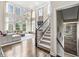 Bright living room with large windows, a modern staircase, wood floors, and a comfortable seating area at 209 North Bnd, Greenwood, IN 46142