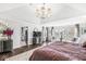 Well-lit main bedroom with decorative chandelier and a sitting area by the window at 209 North Bnd, Greenwood, IN 46142