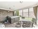 A relaxing sunroom features a hot tub, tile flooring, brick accent wall, and an outdoor view at 209 North Bnd, Greenwood, IN 46142