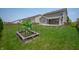 Spacious backyard featuring a well-maintained lawn, covered patio, and planted garden at 2324 Boneset Dr, Plainfield, IN 46168