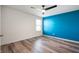 Modern bedroom with sleek laminate flooring, a ceiling fan, and a vibrant accent wall at 2324 Boneset Dr, Plainfield, IN 46168