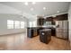 Modern kitchen with stainless steel appliances, an island, dark cabinets, and wood flooring at 2324 Boneset Dr, Plainfield, IN 46168