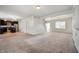 Open-concept living space with the kitchen in the background, neutral carpet, and white walls at 2324 Boneset Dr, Plainfield, IN 46168