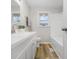 White bathroom featuring vinyl wood floors, modern fixtures, and a window above the toilet at 3013 E 7Th St, Anderson, IN 46012