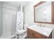 Bathroom with a white tiled shower, decorative shower curtain and an ornate wooden vanity at 3045 N Lasalle St, Indianapolis, IN 46218