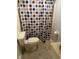 Compact bathroom with a shower, toilet, and sink, featuring a colorful polka dot shower curtain at 318 Tague St, Greenfield, IN 46140