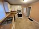 Functional kitchen with white cabinets, laminate counters, tile floors and a view to an adjacent room at 318 Tague St, Greenfield, IN 46140