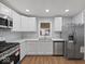 Bright kitchen showcasing updated stainless steel appliances and white cabinetry at 329 Roosevelt Dr, Shelbyville, IN 46176