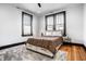 Bedroom with hardwood floors, ceiling fan, and updated black-trimmed windows for ample natural light at 425 E Walnut St, Indianapolis, IN 46202
