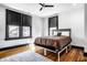 Cozy bedroom with hardwood floors, large windows, ceiling fan, and stylish black window trim at 425 E Walnut St, Indianapolis, IN 46202