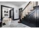 Inviting foyer featuring black trim, hardwood floors, white walls, and a staircase at 425 E Walnut St, Indianapolis, IN 46202
