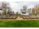 Backyard featuring raised garden beds enclosed by a wooden fence and mulch, a lawn, and buildings at 4610 W 72Nd St, Indianapolis, IN 46268