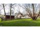The backyard features a lawn, a shed, mature trees, and a charming wooden fence at 4610 W 72Nd St, Indianapolis, IN 46268