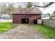 There is a maroon outbuilding with open doorways next to a gravel area and a wood fence at 4610 W 72Nd St, Indianapolis, IN 46268