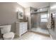 Cozy bathroom with tiled walk-in shower, white vanity, toilet and mushroom-themed towels at 4610 W 72Nd St, Indianapolis, IN 46268