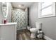Bright bathroom featuring a toilet, vanity and a bathtub with whimsical shower curtain at 4610 W 72Nd St, Indianapolis, IN 46268