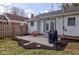 A cozy backyard features a stone patio with chair, lush lawn, and access to the house through elegant French doors at 5937 Guilford Ave, Indianapolis, IN 46220