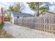 Fenced backyard with gravel driveway, wooden fence, and detached garage at 5937 Guilford Ave, Indianapolis, IN 46220