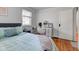 Bright bedroom featuring a desk, wood floors, neutral wall paint, and a comfortable bed with light green bedding at 5937 Guilford Ave, Indianapolis, IN 46220