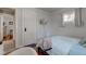 Bright bedroom featuring wood floors, neutral wall paint, a comfortable bed with light green bedding, and a TV mounted on the wall at 5937 Guilford Ave, Indianapolis, IN 46220
