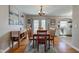 Warm dining area featuring hardwood floors, modern light fixture, and adjacent view of the kitchen at 5937 Guilford Ave, Indianapolis, IN 46220