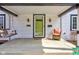 Inviting front porch with a hanging swing, chair, and a green front door at 5937 Guilford Ave, Indianapolis, IN 46220