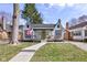 Charming cottage-style home featuring a manicured lawn, inviting walkway, and a cozy front porch with an American flag at 5937 Guilford Ave, Indianapolis, IN 46220