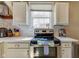 Modern kitchen featuring stainless steel appliances, white cabinets, and tile backsplash at 5937 Guilford Ave, Indianapolis, IN 46220