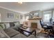 Comfortable living room with a fireplace, mounted TV, gray couch with decorative pillows, and a work-from-home setup at 5937 Guilford Ave, Indianapolis, IN 46220