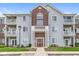 Three-story condo building with multiple balconies, brick accents, and well-maintained landscaping at 6231 Amber Creek Ln # 312, Indianapolis, IN 46237
