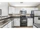 Well-maintained kitchen featuring white cabinets, black appliances, and neutral-colored walls at 6231 Amber Creek Ln, Indianapolis, IN 46237