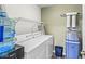 Functional laundry room including a washer, dryer, shelving, and water filtration system at 6231 Amber Creek Ln, Indianapolis, IN 46237