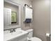 Neutral powder room featuring a decorative mirror, white vanity, and storage cabinet with a towel bar at 6611 Valley Mills Ave, Indianapolis, IN 46241
